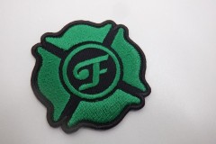 緑色の刺繍糸で四葉の校章のようなデザインの中心に文字が刺繡されたオリジナル刺繡ワッペンの制作実績。