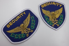 羽を広げた金の鷲と鍵のデザインの刺繡をした、警備会社のオリジナル刺繡ワッペンの制作実績。