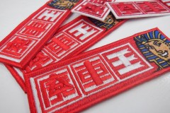 赤い生地に赤・白で会社名を、横にツタンカーメンも刺繡したオリジナル刺繡ワッペンの制作実績。