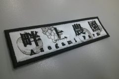 フルーツの昇華転写プリントを施した生地に農園名を黒糸で刺繡した、オリジナル刺繡ワッペンの制作事例。