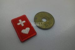 五円玉と比較しても変わらない大きさで刺繡した、ヘルプマークのオリジナル刺繡ワッペンの制作実績。