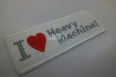 白色のクロス生地にメッセージの一部をタタミ縫いとサテン縫いのハートマークで刺繡した、オリジナル刺繡ワッペンの制作事例。