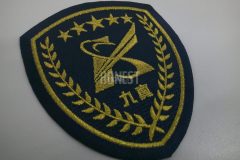 黒色の生地に金糸で月桂冠と５つの星でロゴと企業名を囲んだ刺繡をした、オリジナル刺繡ワッペンの制作事例。