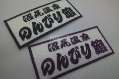 白色の生地に施設名をそれぞれ黒とエンジの単色糸で刺繡した、二種類のオリジナル刺繡ワッペンの制作実績。