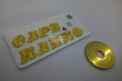 白色のクロス生地に金糸で観光バス会社名と三色の星を刺繡した、オリジナル刺繡ワッペンの制作事例。