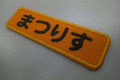 濃いめのオレンジのツイル生地に丸ゴシック体で平仮名4文字を刺繍したもったいないワッペンの作品事例。