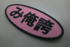 ピンクの生地をベースに黒糸で意味深な3文字を刺繍した、もったいないワッペンの制作事例。