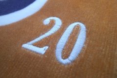 オレンジ色のチームオリジナルタオルに背番号を刺繡した部分のアップ。