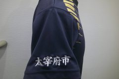紺色のバレーボールユニフォームの右袖に白糸で地域名を刺繍した制作事例。