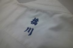 柔道着の衿下に紺糸で個人名を縦方向に刺繡した制作事例。