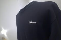 黒Tシャツの左胸に個人名を白糸で刺繡した制作事例の別角度。