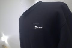 黒Tシャツの左胸に個人名を白糸で刺繡した制作事例の別角度。