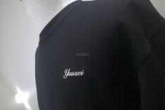 黒Tシャツの左胸に個人名を白糸で刺繡した制作事例。