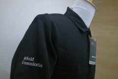 お持ち込みの黒ポロシャツの右袖に銀糸で企業名を刺繡した制作事例。
