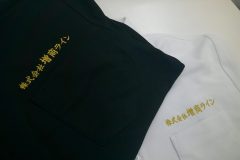 黒ポロシャツと白ポロシャツの左胸に金糸で企業名を刺繍した加工見本。