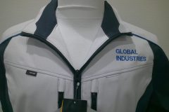 お持ち込みの作業服の左胸にサックスブルーの糸で会社名を二段構成でネーム刺繍を加工した制作事例。