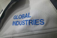 お持ち込みの作業服の左胸にサックスブルーの糸で会社名を刺繍した制作事例のアップ。