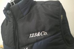 お持ち込みダウンベストの左胸に銀糸で企業ロゴを刺繡した制作事例。