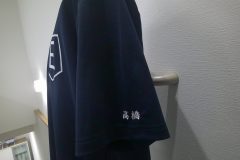 紺色ポロシャツの左袖に白糸で個人名の刺繍をした制作事例。