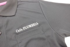 黒ポロシャツの左胸に白糸でカフェの店名を刺繡した制作事例。