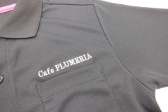 黒ポロシャツの左胸に白糸でカフェの店名を刺繡した制作事例。