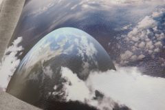 グレーのパーカー背面に地球の写真と英文メッセージがプリントされたフルカラー転写プリントの制作見本のアップ。色鮮やかな加工が印象的。