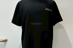 黒いTシャツの左胸にグリッターシルバーのシートで社名ロゴをプリントしたラバープリントの制作実績。全体を表示。