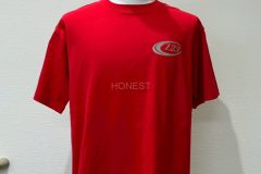 赤いTシャツの左胸にグリッターシルバーのシートで社名マークをプリントしたラバープリントの制作実績。全体を表示。