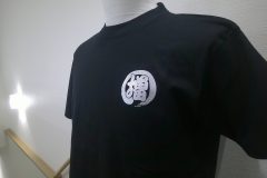 黒いTシャツの左胸にグリッターシルバーのシートで運送会社のシンボルマークをプリントしたラバープリントの制作実績。