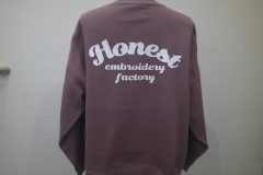 モーブのトレーナーの背中全面に白いシートで大きく「Honest」のロゴを配置したラバープリントの制作見本。