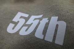 杢グレーのトレーナーに白いシートで55周年マークのワンポイントのプリント部分をアップ。