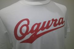 白いTシャツの胸中央に、赤いシートで大きく筆記体のチームロゴを配置したラバープリントの制作実績。