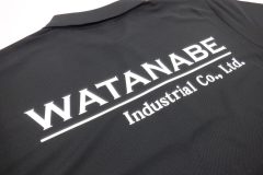 黒いカノコポロシャツの背中中央に白いシートで社名ロゴをプリントしたラバープリント部分のアップ。