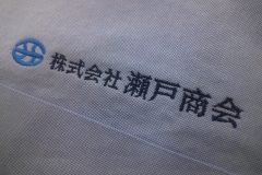 お持ち込みのシャツ左胸に青と紺の社名ロゴを刺繍した制作事例アップ。