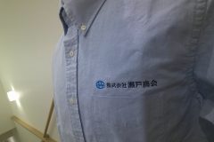 お持ち込みシャツの左胸に青とネイビーの糸で社名ロゴを刺繍した、会社名刺繍の制作実績。