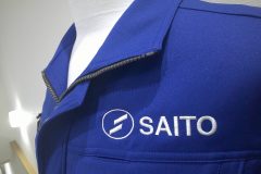 お持ち込みの作業服に白糸でサテン縫いをメインに会社名を刺繍した制作事例のアップ。