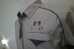 チェック柄のチュニックに漢字のロゴと英字のロゴが二段構成として刺繍加工をした制作事例。
