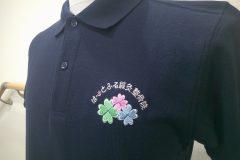 緑・ピンク・ブルーを基調としたオリジナル刺繍をポロシャツの左胸に加工した制作事例。