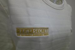 白のTシャツの右胸にメタリック金糸で自動車メーカーのロゴを刺繍した、オリジナル刺繍の制作事例のアップ。