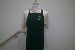 お持ち込みのエプロンの左胸に白糸単色で美容室のロゴを刺繍した制作実績。