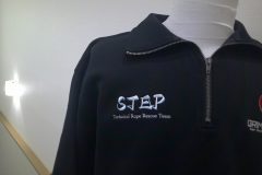お持ち込みのハーフジップスウェットの右胸にレスキュー隊のロゴ文字をオリジナル刺繍加工した制作実績。