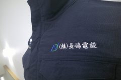作業服の左胸にシンプルな企業ロゴを刺繍した制作事例のアップ。