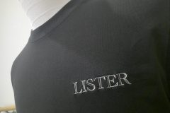 黒のTシャツの左胸に品のあるフォントで店名を加工した、オリジナル刺繍の制作事例。糸色は白糸。