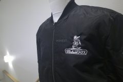MA-1ジャケット（黒）の左胸にリフォーム会社のロゴを白糸で刺繍をした制作事例。