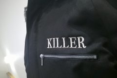 黒の防寒ジャケットの左胸にチーム名をオリジナル刺繡として、銀糸単色で加工した制作事例のアップ。
