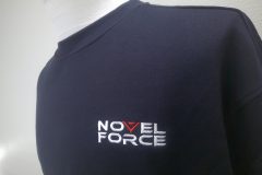 お持ち込みのネイビーのスウェットの左胸に会社のロゴを刺繍加工した制作事例のアップ。