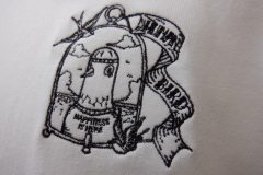 お持ち込みのTシャツに窓際に止まった鳩の線画を美しく刺繍した制作事例。