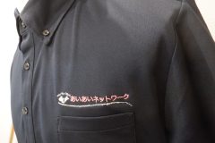 ポロシャツの左胸に介護施設名を淡い水色・黄色・ピンクでパステルカラーで刺繍をした制作事例。