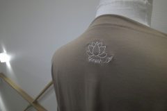 お持ち込みのTシャツの背中衿下に蓮の花をモチーフとしたブランドロゴを線画テイストで刺繍。糸の色はオフホワイトを使用。