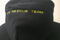 お持ち込みのパーカーフード部分に黄色の糸で「ROPE RESCUE TEAM」のロゴ文字を刺繍した制作実績。